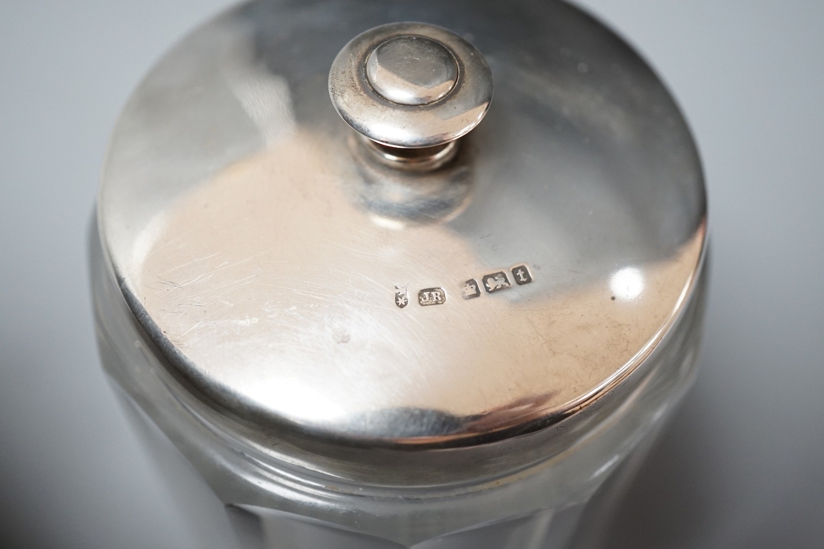 Sundry small silver including a mounted glass match tidy(a.f.), a silver christening mug(a.f.), mounted glass preserve jar, three napkin rings, six items of flatware, thimble T-bar and a sterling bangle.